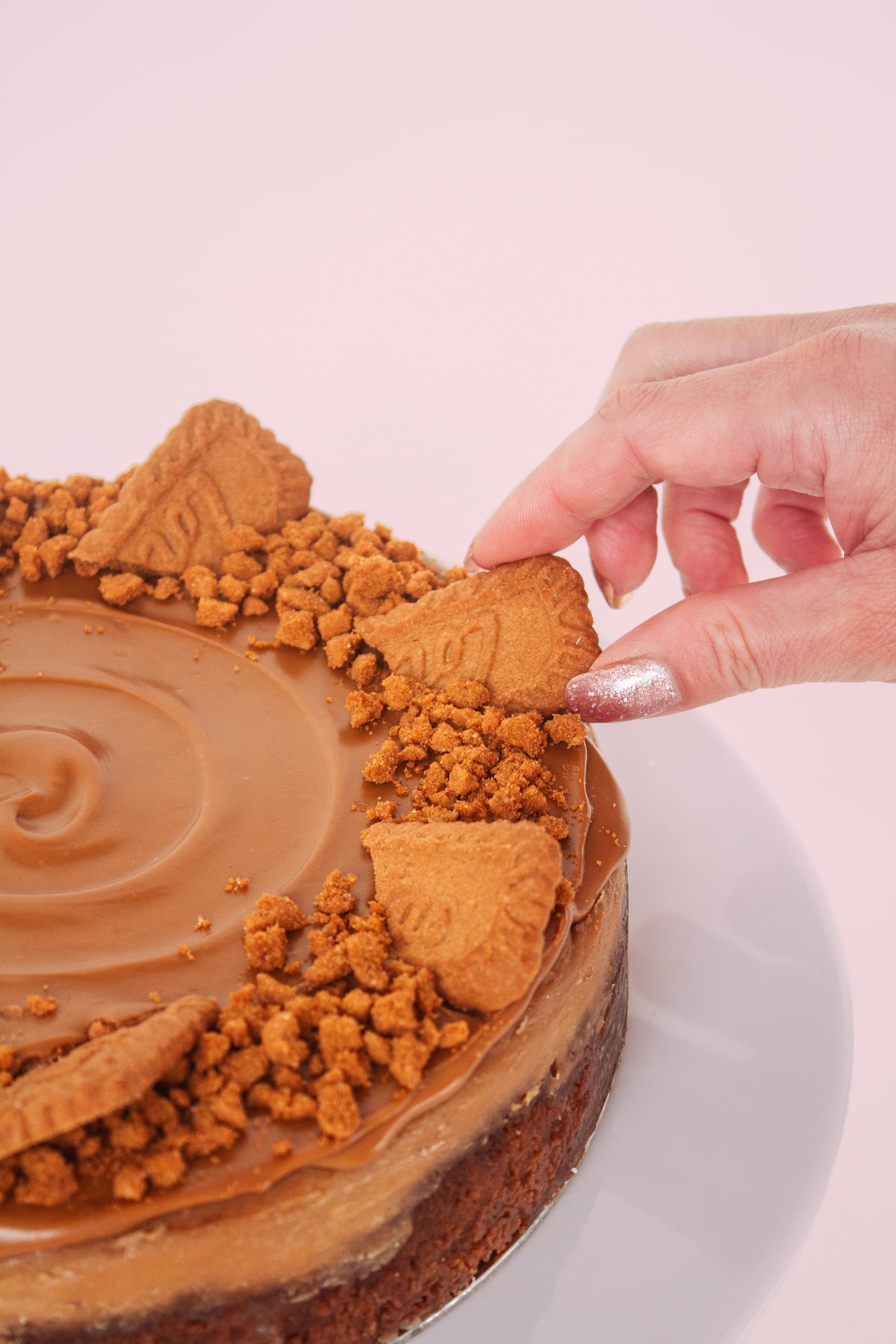 Someone taking a biscuit from Biscoff Cheesecake