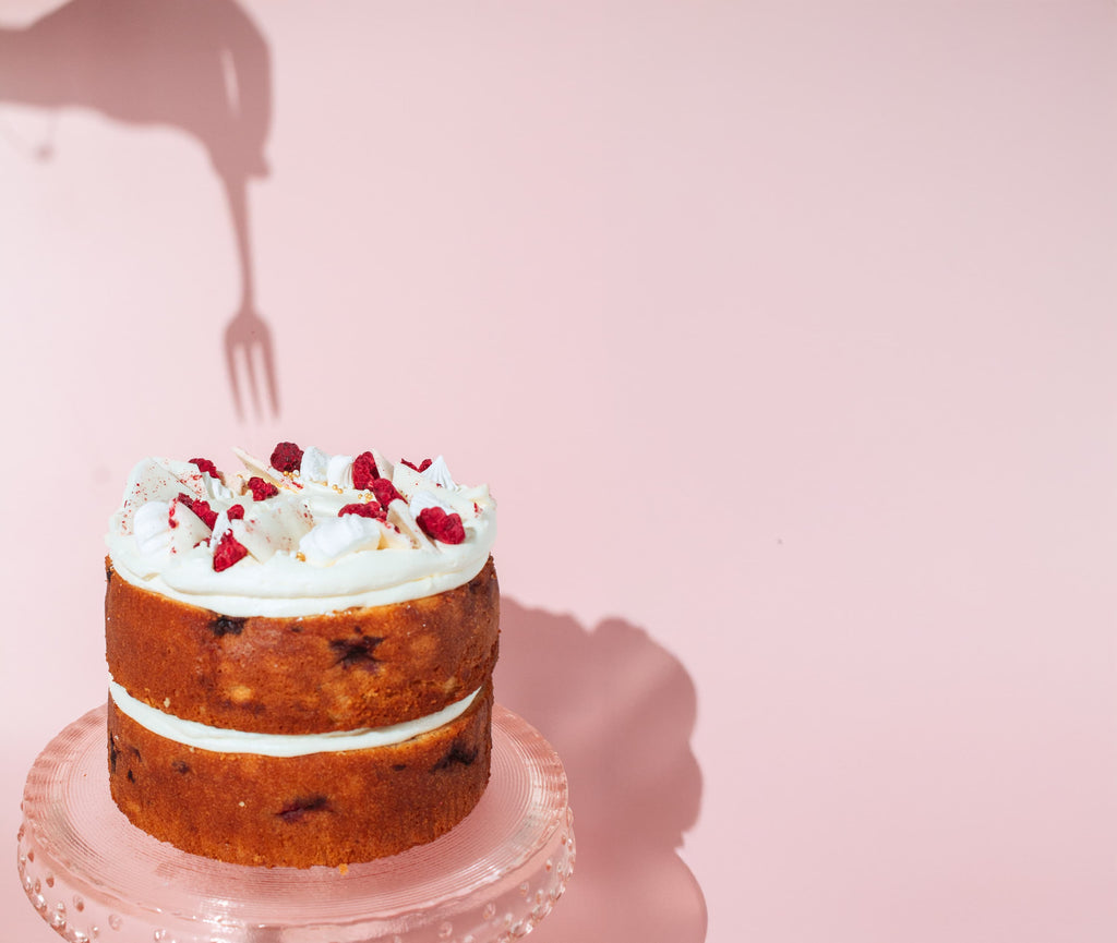 a shadow of a fork going into a lemon raspberry cake