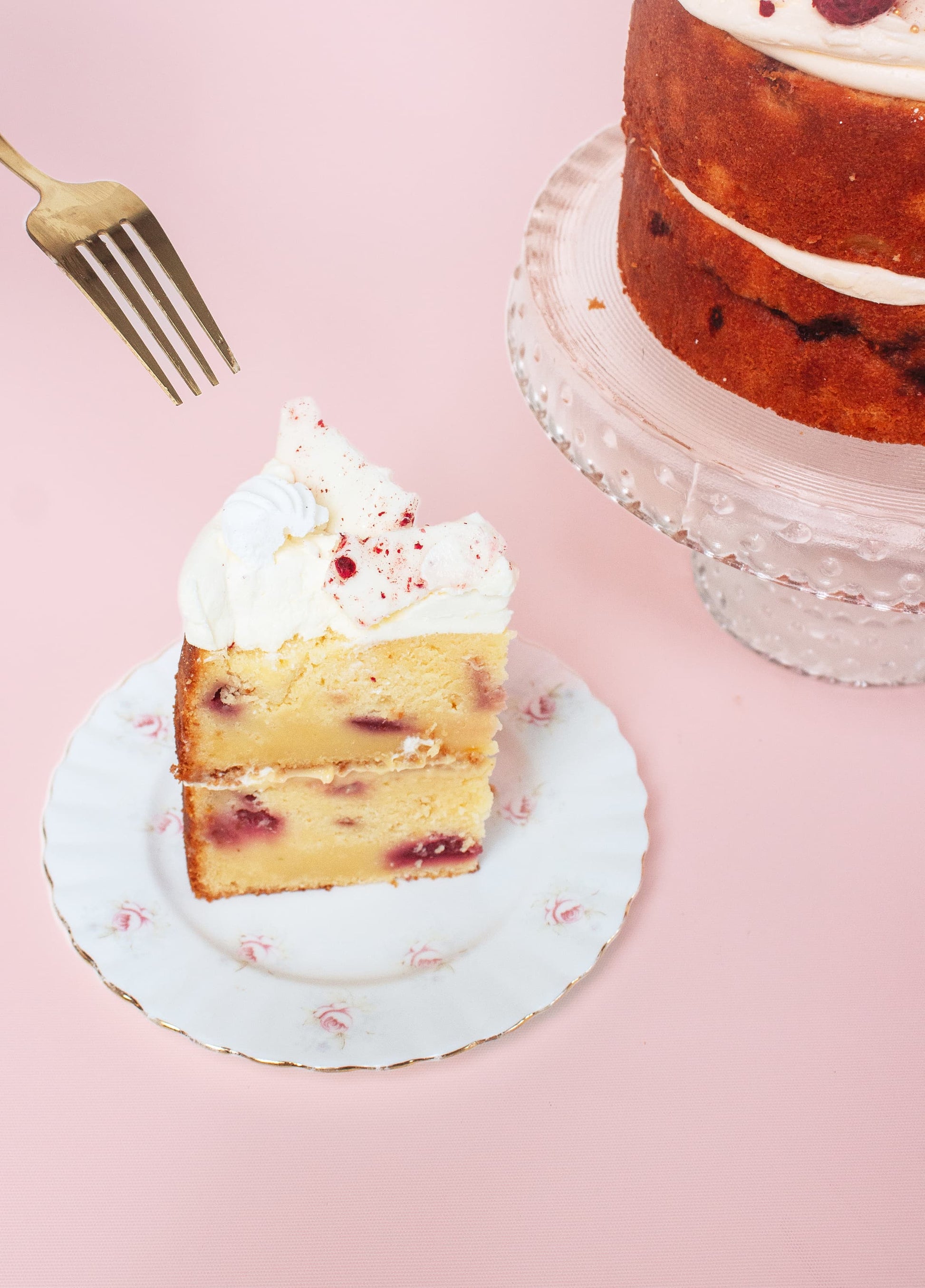 A fork going into a slice of lemon raspberry cake