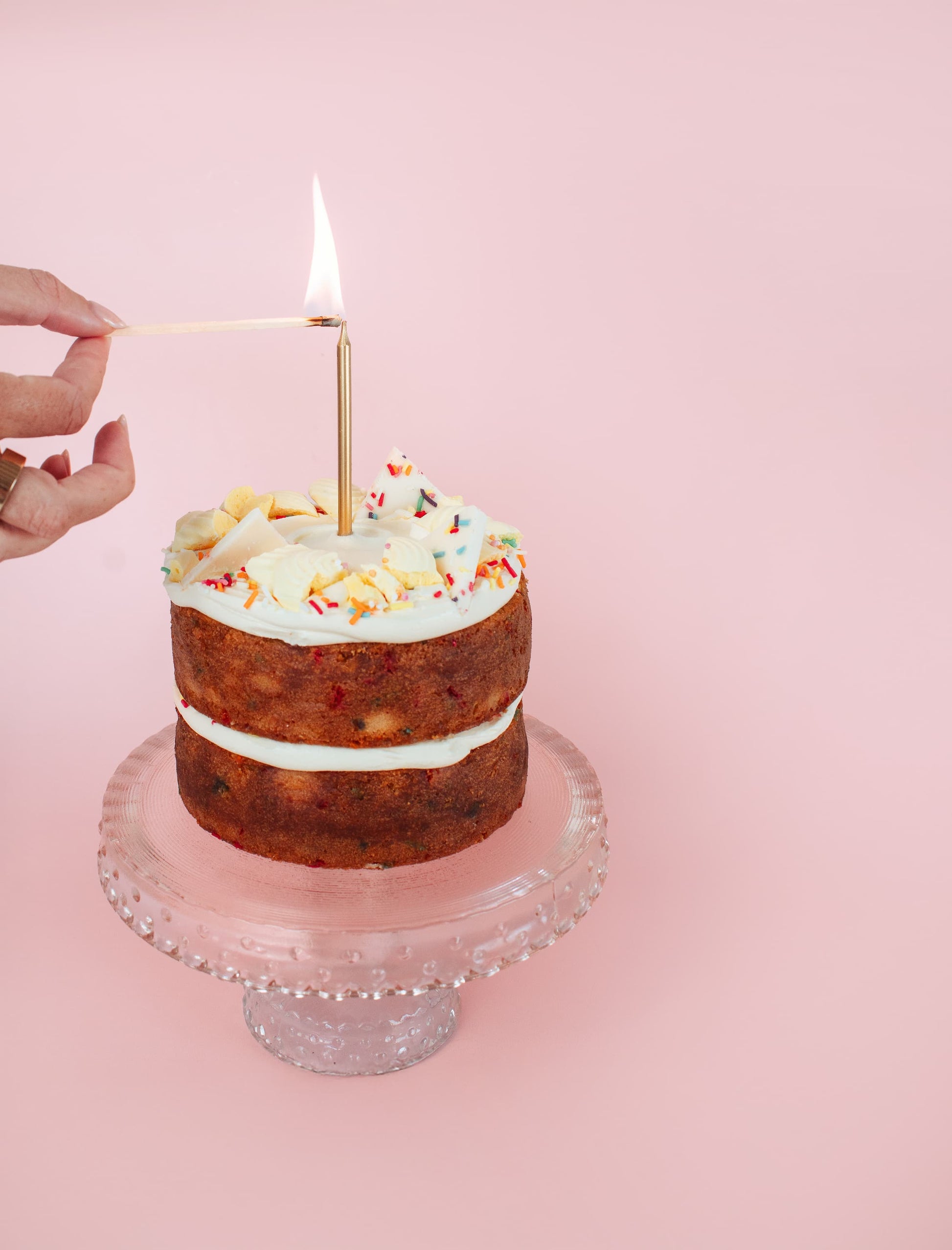 lighting a candle on a vanilla funfetti cake