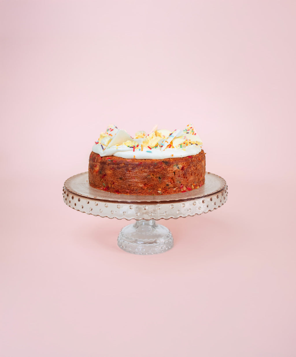 vanilla cake with sprinkles on a cake stand