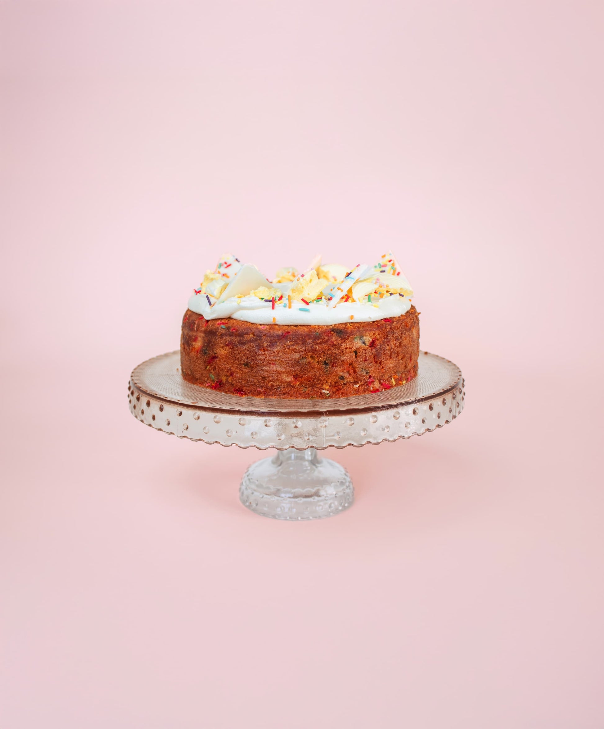 vanilla cake with sprinkles on a cake stand
